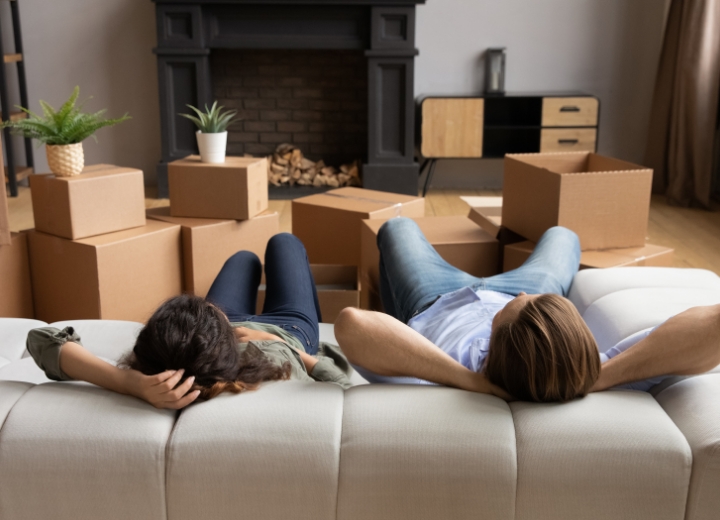 People relaxing on a couch in their newly moved in home.